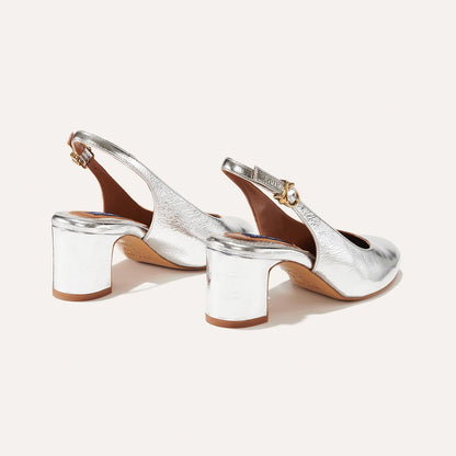 The Cluny Slingback in shiny Silver Crinkle Nappa, featuring a sleek Italian nappa leather upper with an adjustable buckle and a comfortable 2.5-inch black heel.