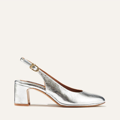 The Cluny Slingback in shiny Silver Crinkle Nappa, featuring a sleek Italian nappa leather upper with an adjustable buckle and a comfortable 2.5-inch black heel.