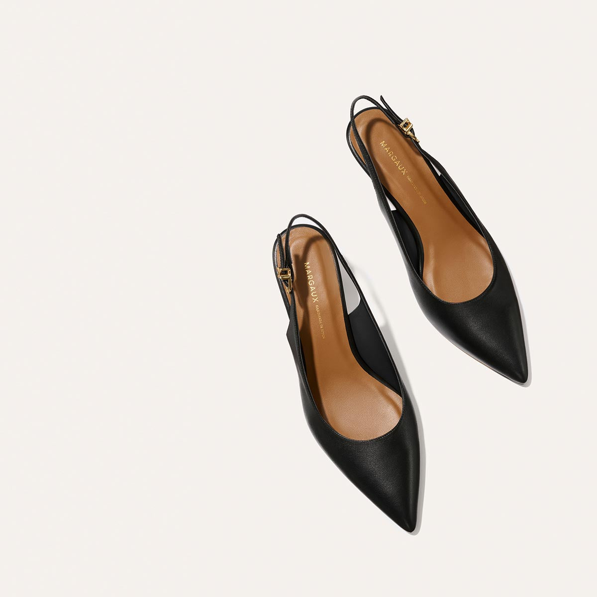 The Colette - Black Nappa by margaux-development: black snip nose pointed-toe slingback flats with tan insoles and gold buckle detail, shown on a plain white background.