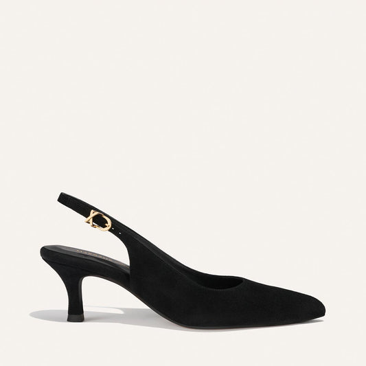 The Colette by Margaux is a black suede slingback heel with a pointed toe, mid-height curved heel, and gold buckle on the ankle strap, shown against a plain white background.