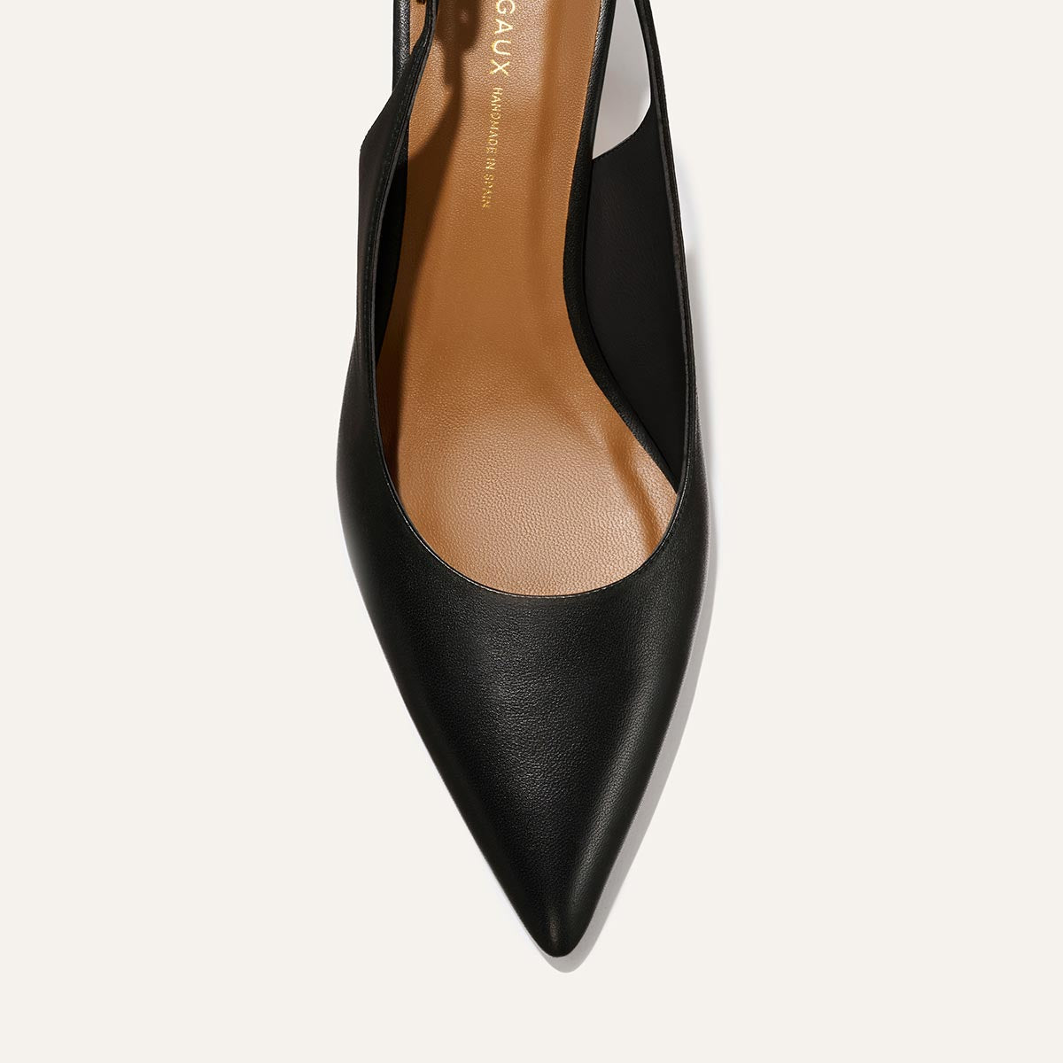 A top view of The Colette - Black Nappa by margaux-development, featuring a black snip nose pointed toe, tan insole, and slingback design against a light background.