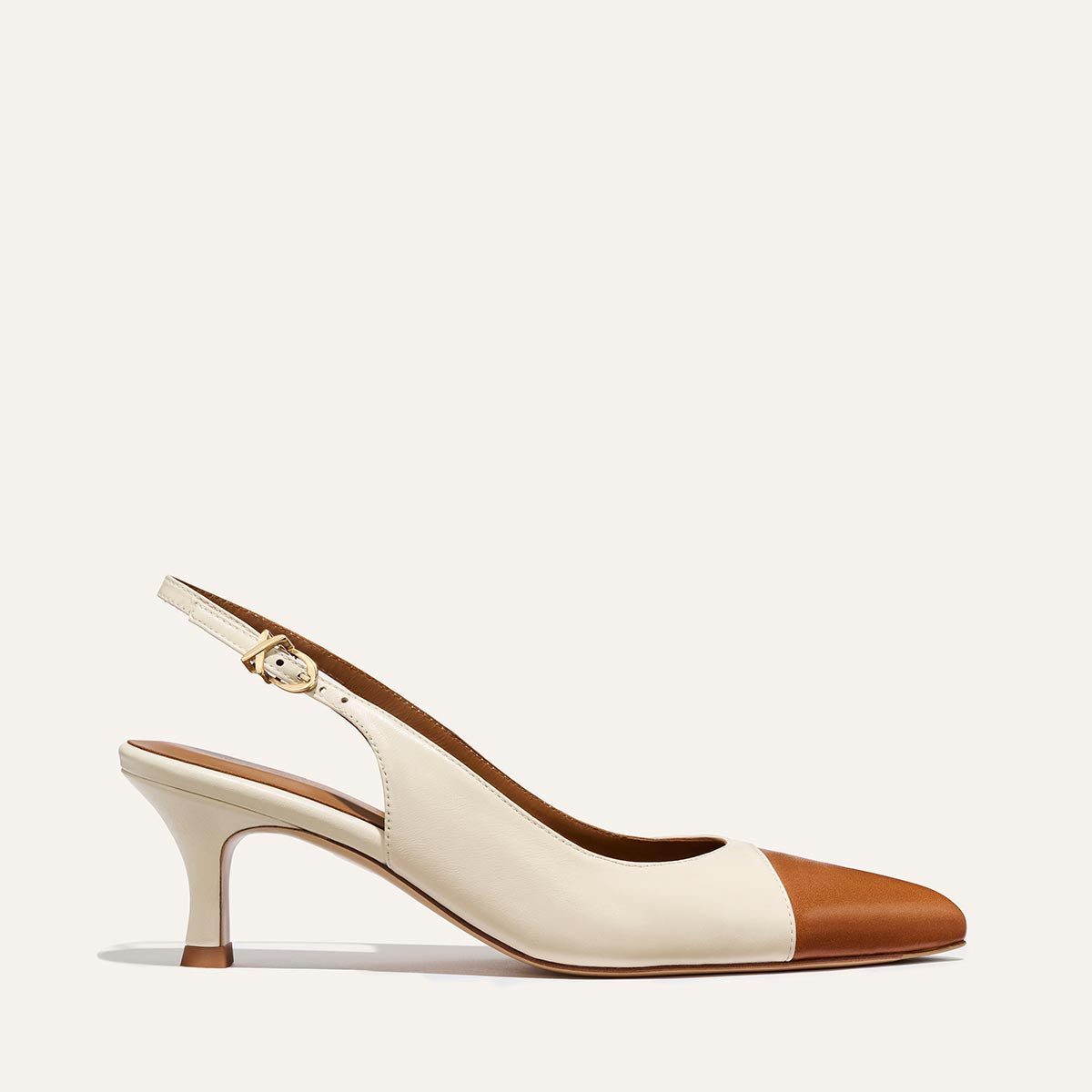 The Colette by Margaux: a beige and brown nappa slingback with a snip toe, mid-height micro heel, and gold buckle strap, shown on a plain light background.