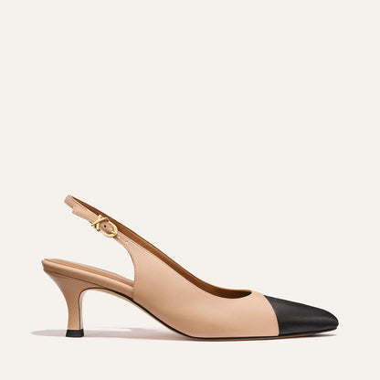 The Colette - Dune and Black Nappa by Margaux is a beige slingback heel with a black cap toe, mid-height micro heel, and an ankle strap with gold buckle, shown on a plain light background.