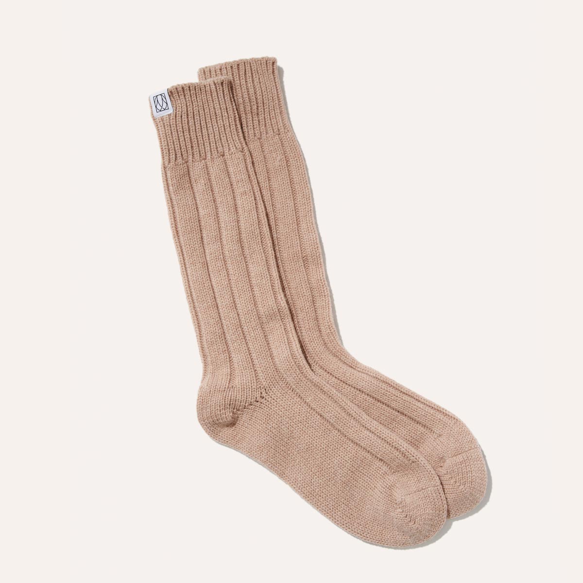 Margauxs The Cozy Sock in Oatmeal, crafted from a luxurious wool-cashmere blend, features a ribbed crew design and soft finish—perfect for lounging in style.