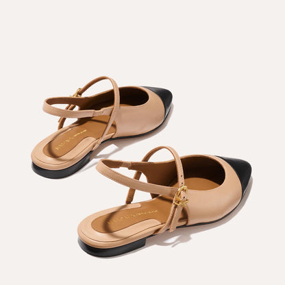 A neutral leather mary-jane flat with a black cap toe