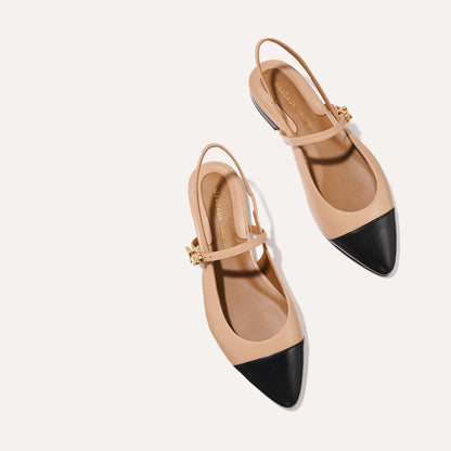 A neutral leather mary-jane flat with a black cap toe
