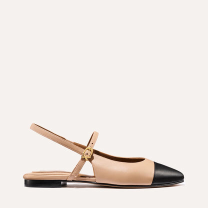 A neutral leather mary-jane flat with a black cap toe