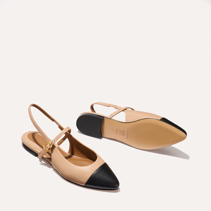 A neutral leather mary-jane flat with a black cap toe