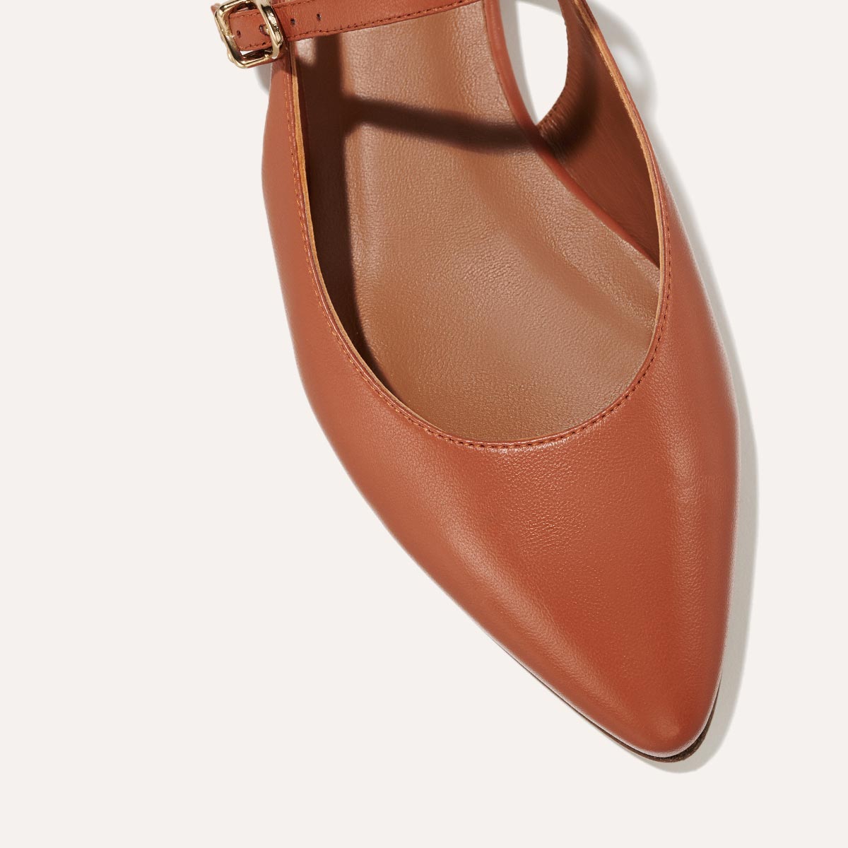 The Cluny Slingback in Saddle Nappa, a ballet flat with a pointed toe, a slingback strap and an adjustable strap across the top of the foot for a secure fit.