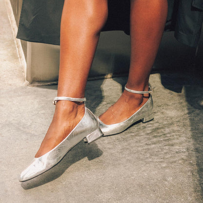 The Daphne in shiny Silver Crinkle Mirror, featuring a chic square toe, a supportive ankle strap and a versatile 1-inch block heel,