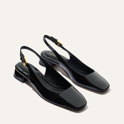 The Darcy Slingback - Black Patent by Margaux features shiny black patent leather, low square heels, square toes, and gold buckle accents on adjustable slingback straps—ideal for elevating your warm-weather style.