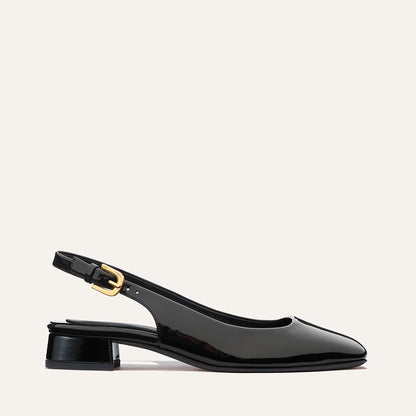 The Darcy Slingback by Margaux in black patent features an adjustable slingback, low block heel, and gold buckle—shown side profile against a light background—perfect for warm-weather style.