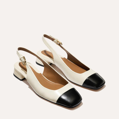 A cap toe low heel slingback with cream and black leather