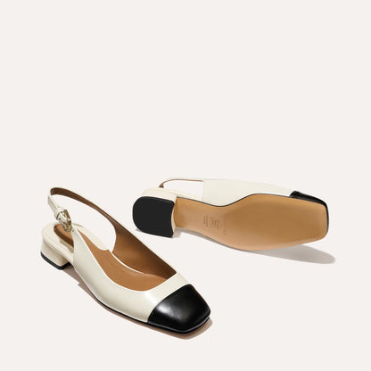 A cap toe low heel slingback with cream and black leather
