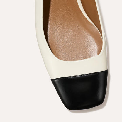 A cap toe low heel slingback with cream and black leather