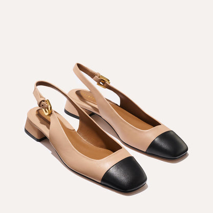 A cap toe low heel slingback neutral and black leather