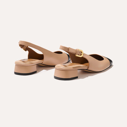 A cap toe low heel slingback neutral and black leather