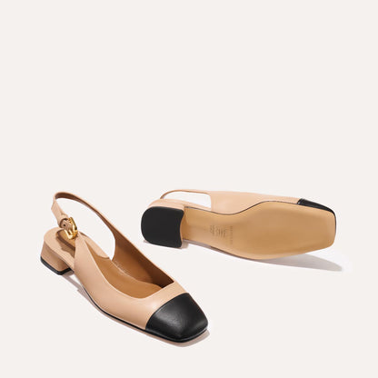 A cap toe low heel slingback neutral and black leather