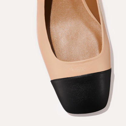 A cap toe low heel slingback neutral and black leather