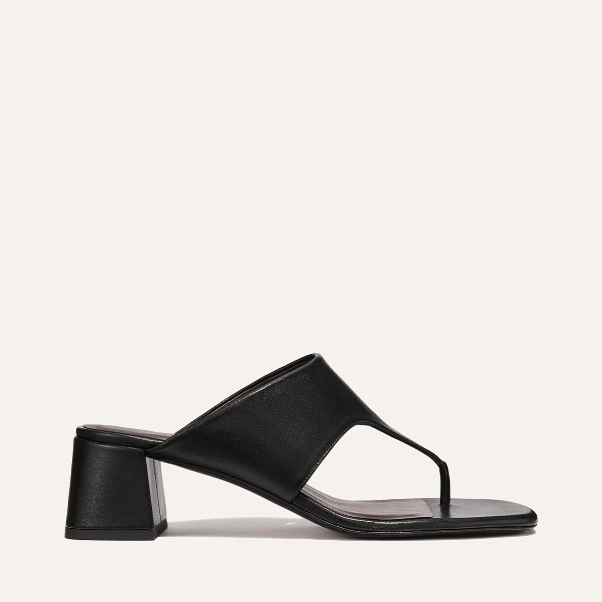 Black sandal on a light beige background