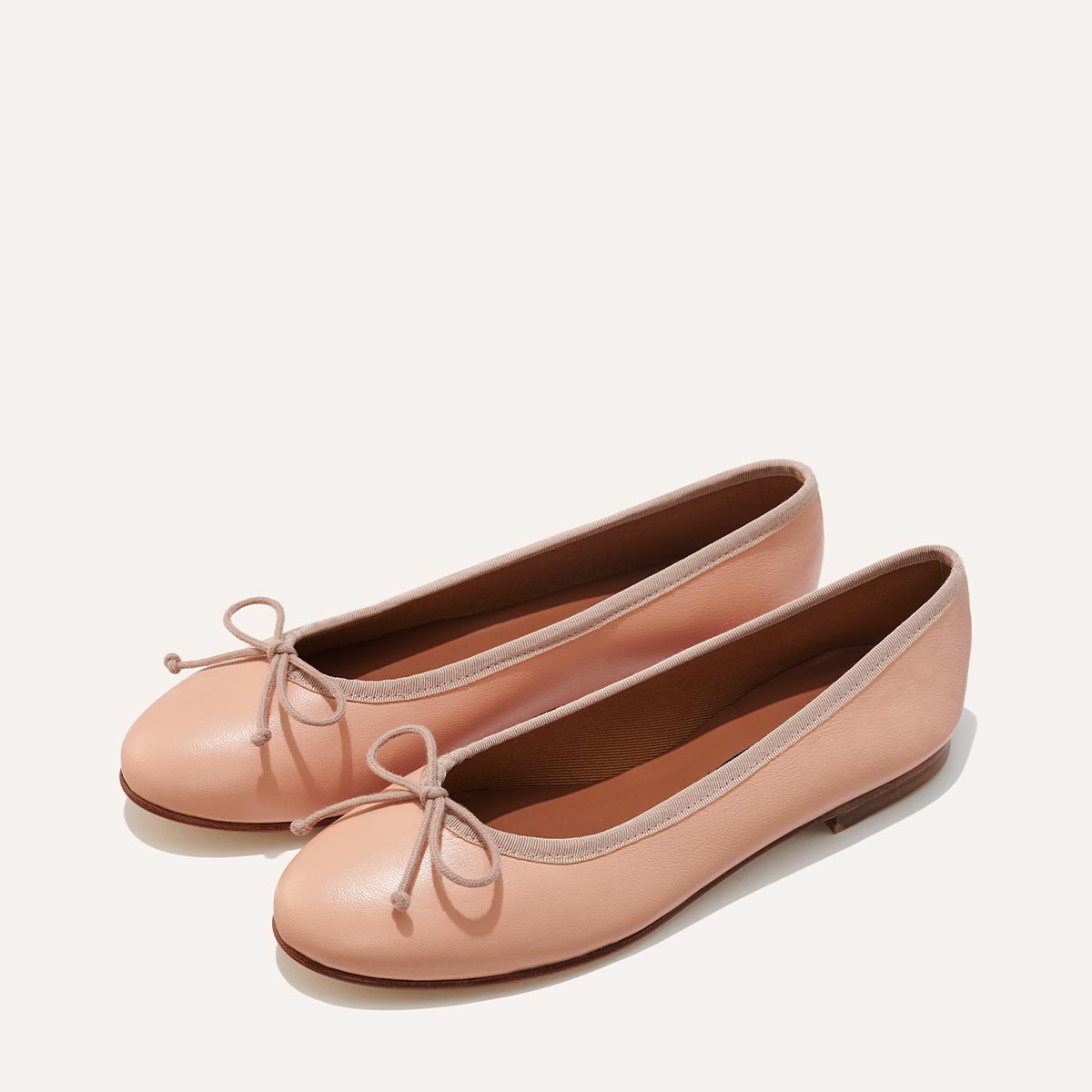 The Demi in Ballet Pink Nappa, a comfortable ballet flat with a rounded toe and adjustable cord bow detail.