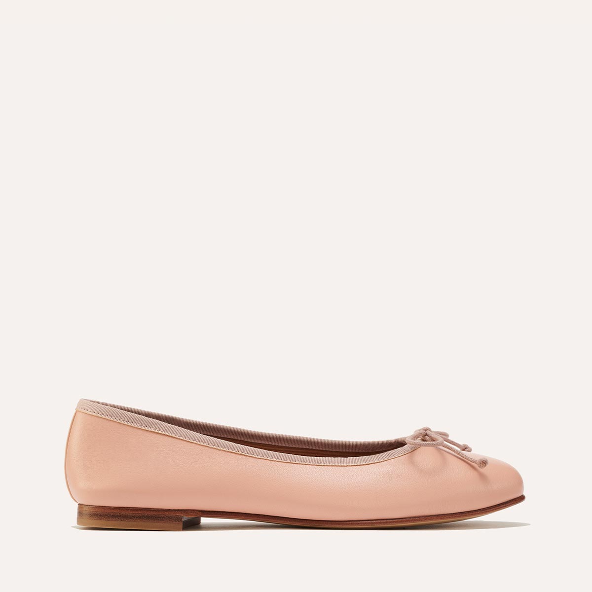 The Demi in Ballet Pink Nappa, a comfortable ballet flat with a rounded toe and adjustable cord bow detail.