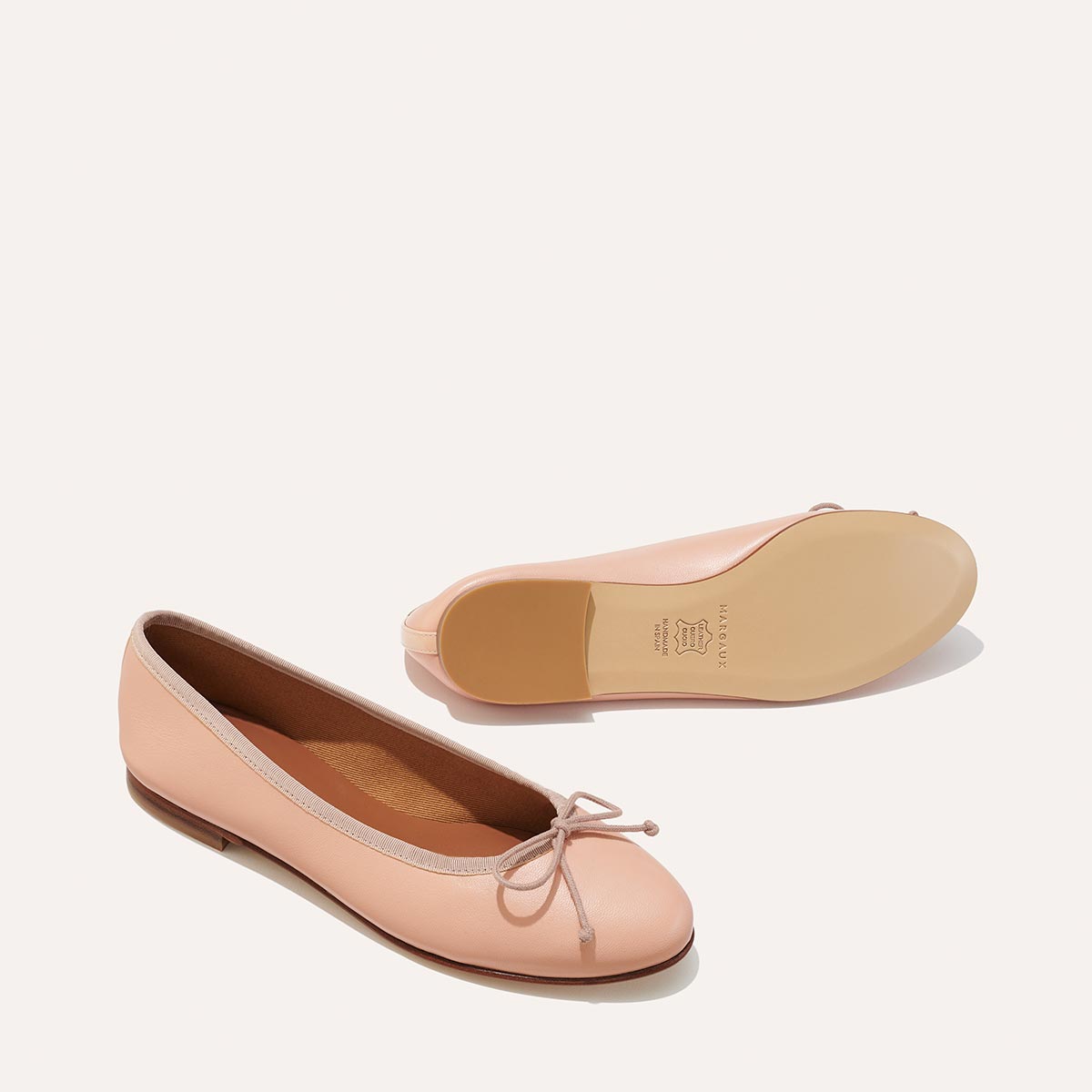 The Demi in Ballet Pink Nappa, a comfortable ballet flat with a rounded toe and adjustable cord bow detail.