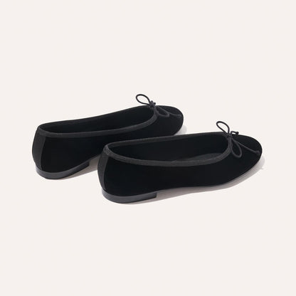 The Demi - Black Velvet by margaux-development: black velvet ballet flats featuring small bows on the toes, shown against a plain light background.