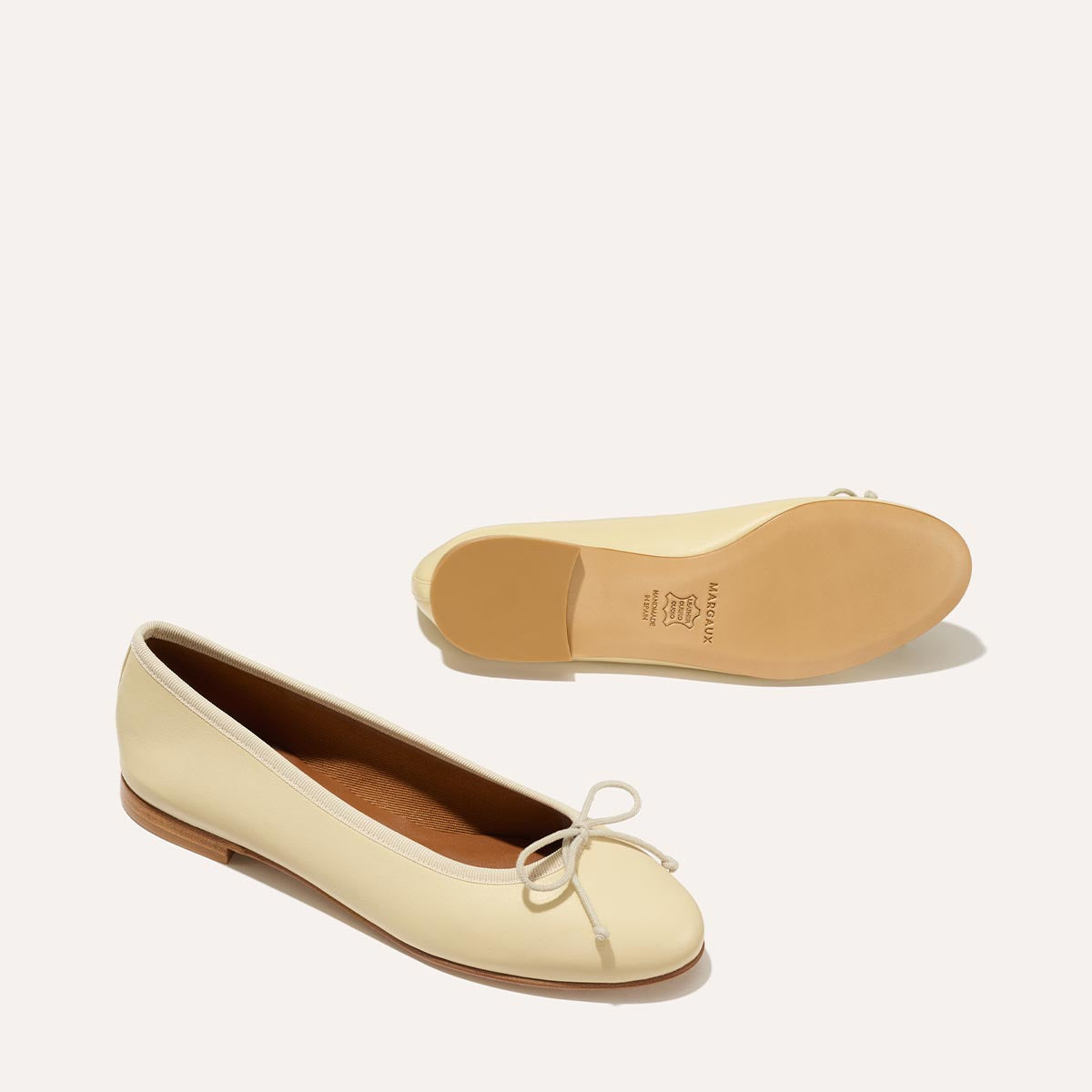 The Demi in light yellow Butter Nappa, a comfortable ballet flat with a rounded toe and adjustable cord bow detail.