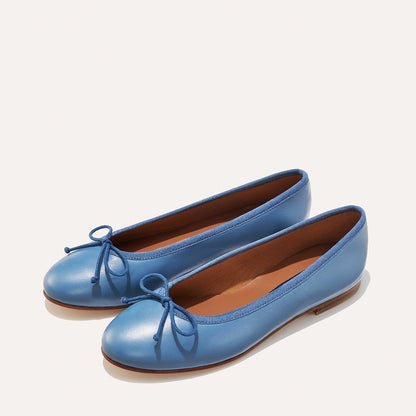 The Demi in cerulean blue nappa, a comfortable ballet flat with a rounded toe and adjustable cord bow detail.