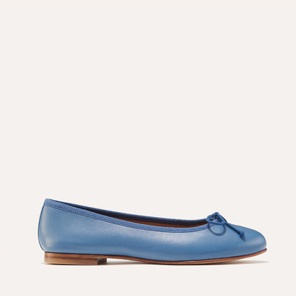The Demi in cerulean blue nappa, a comfortable ballet flat with a rounded toe and adjustable cord bow detail.
