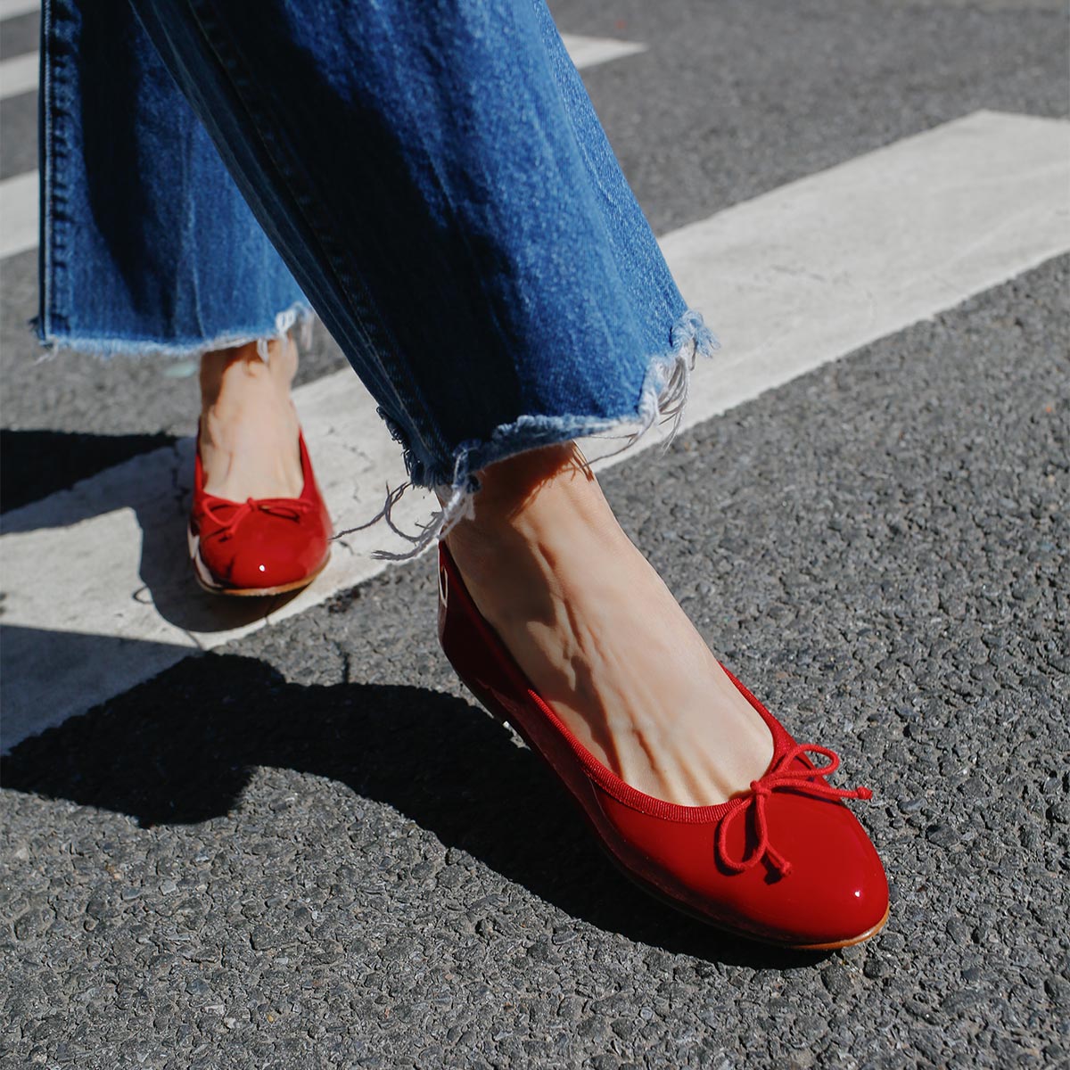 The Demi in Cherry Patent, a comfortable ballet flat with a rounded toe and adjustable cord bow detail.