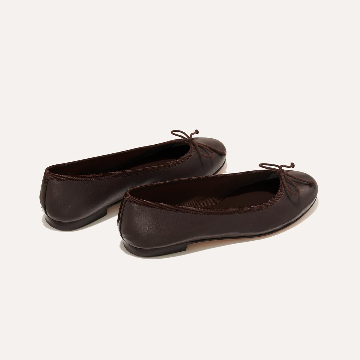 The Demi in Espresso Nappa, a comfortable ballet flat with a rounded toe and adjustable cord bow detail.