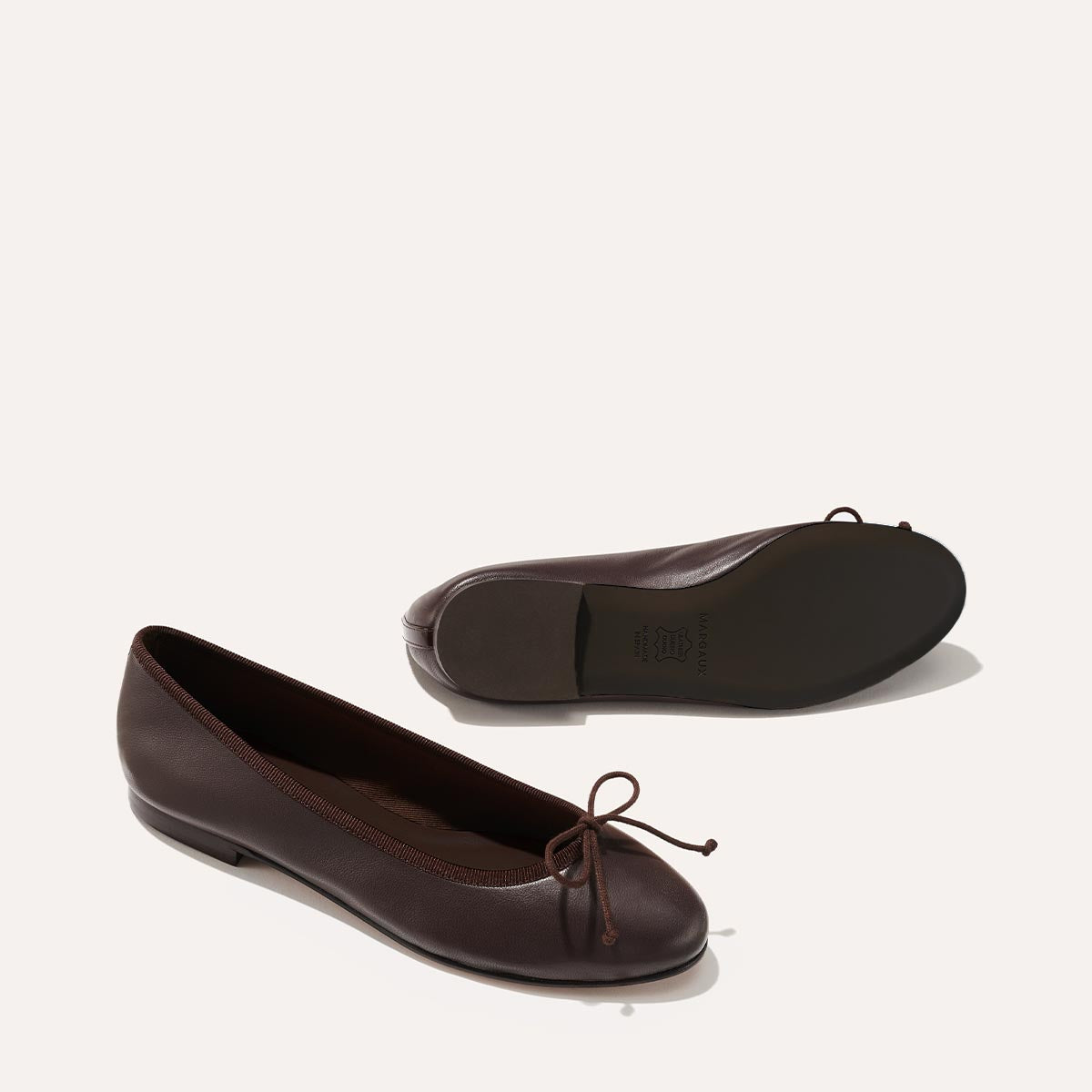 The Demi in Espresso Nappa, a comfortable ballet flat with a rounded toe and adjustable cord bow detail.