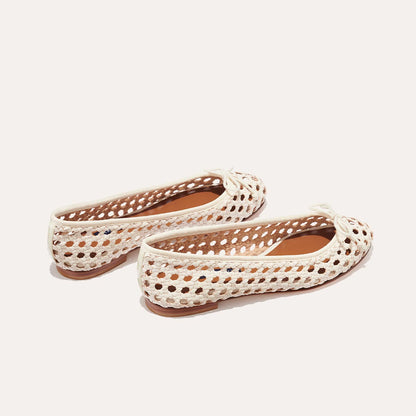 The Demi - Ecru Woven by margaux-development: handmade in Spain, these white woven leather ballet flats feature a perforated design, bow detail on the toe, and tan soles, shown on a plain light background.