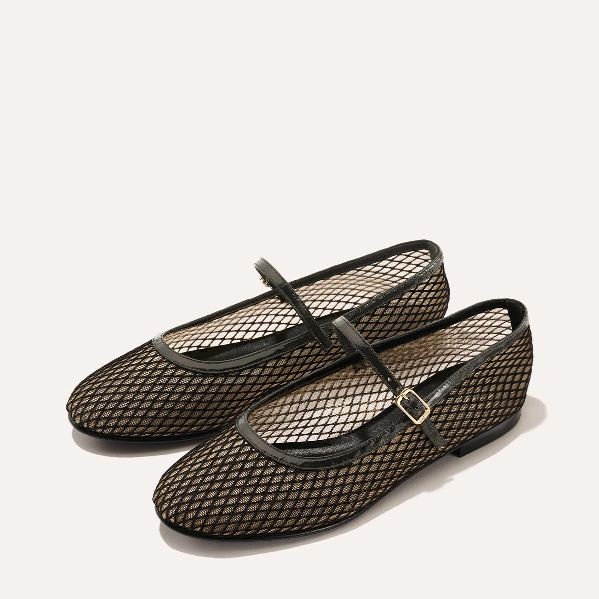 The Demi Jane in Black Fishnet Mesh, a sheer ballet flat with a rounded toe and an adjustable strap for a secure fit.