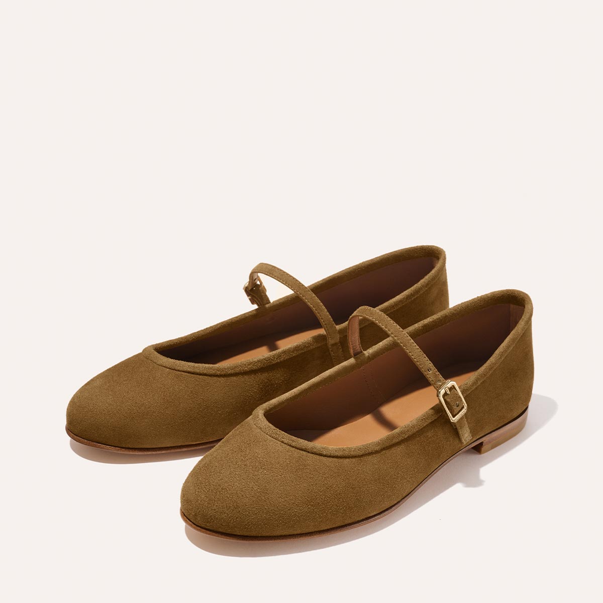 The Demi Jane - Cedar Suede by margaux-development are brown suede Mary Jane flats with rounded toes and a thin strap with a small gold buckle, displayed on a light background.