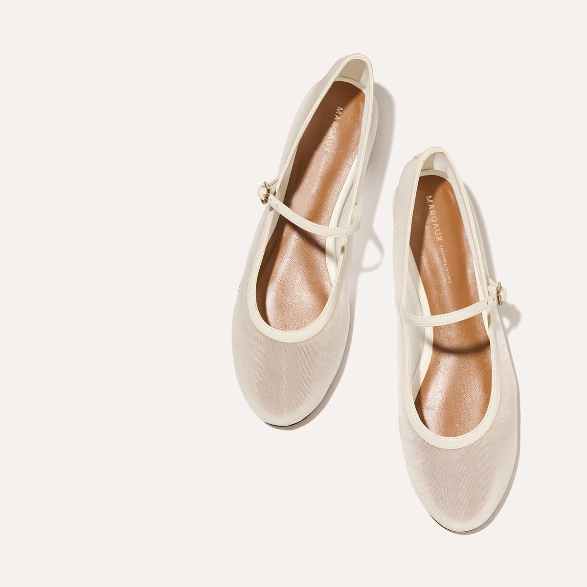 The Demi Jane in Ivory Mesh, a sheer ballet flat with a rounded toe and an adjustable strap for a secure fit.