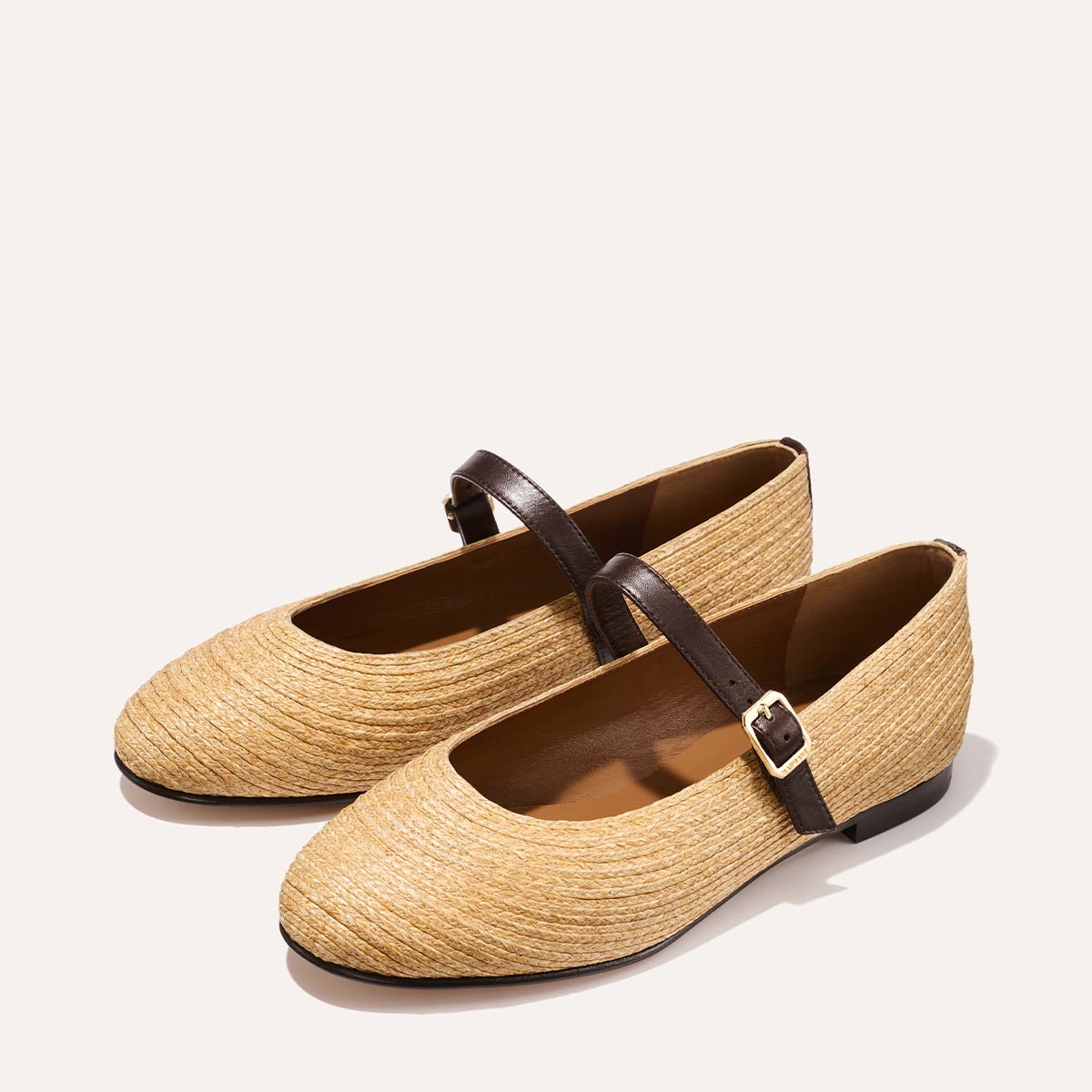 The Demi Jane in natural raffia, a ballet flat with a rounded toe and an adjustable strap for a secure fit.