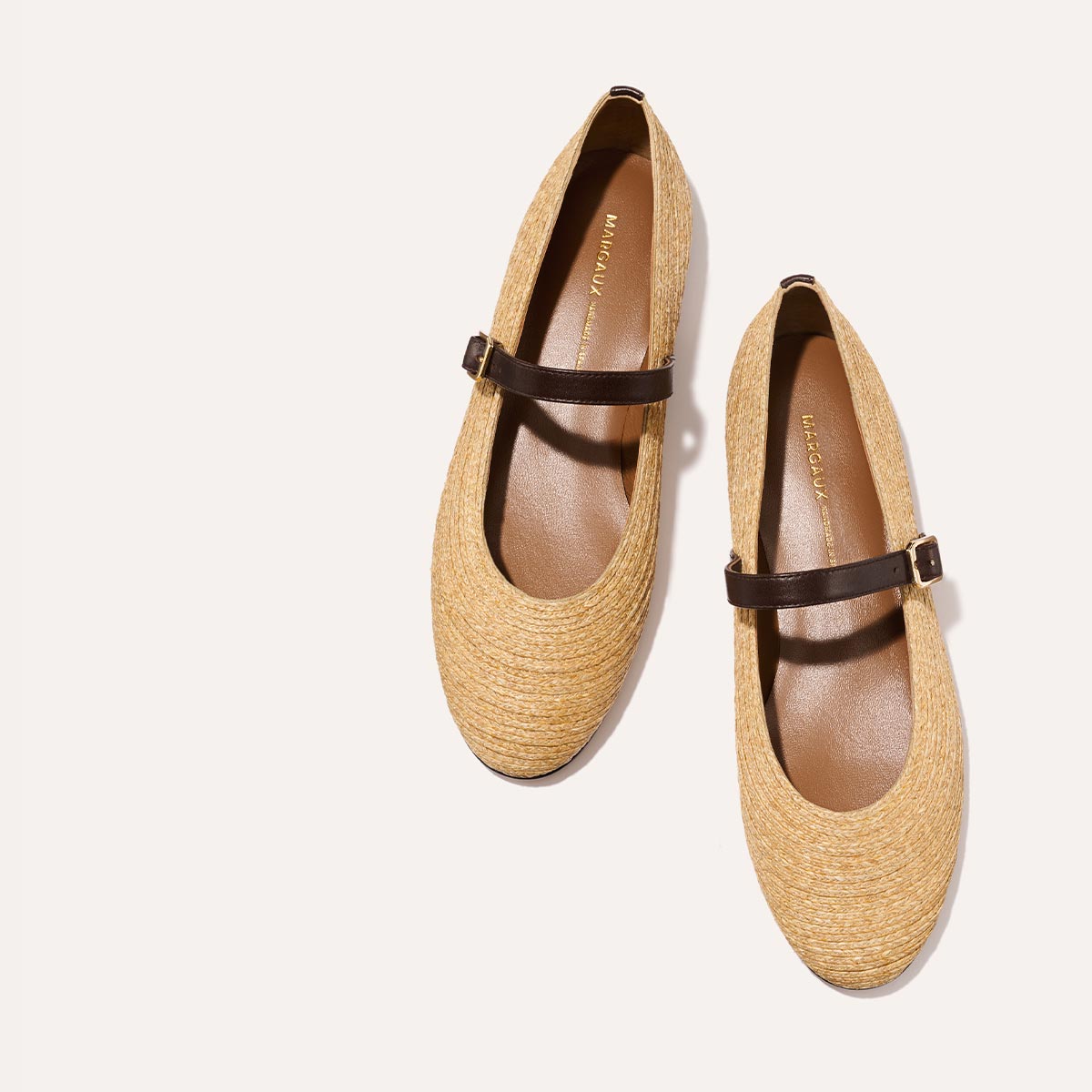 The Demi Jane in natural raffia, a ballet flat with a rounded toe and an adjustable strap for a secure fit.