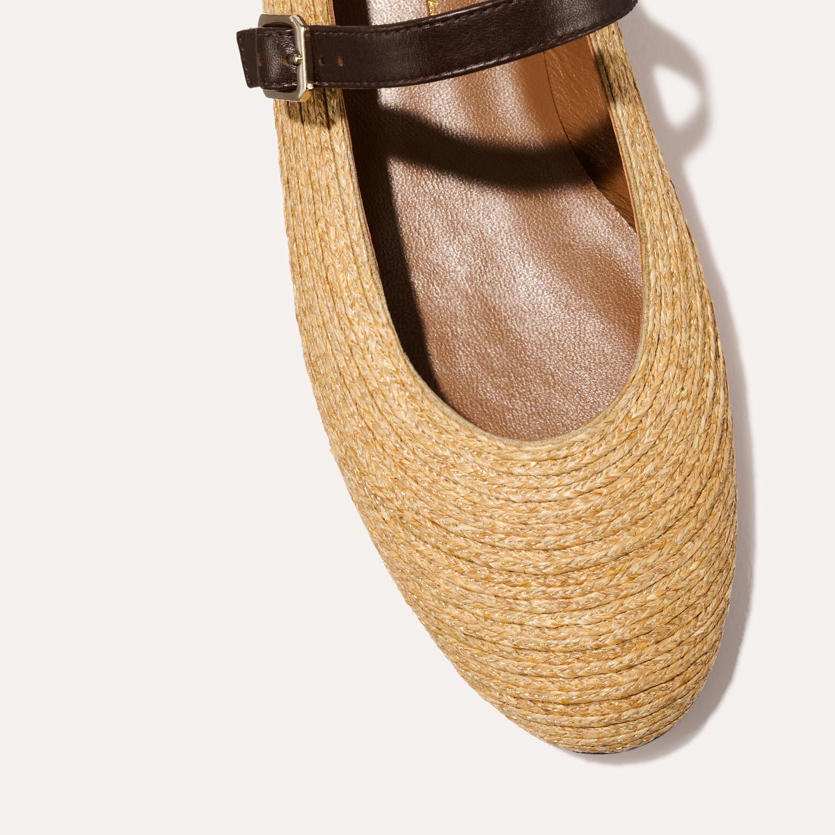 The Demi Jane in natural raffia, a ballet flat with a rounded toe and an adjustable strap for a secure fit.