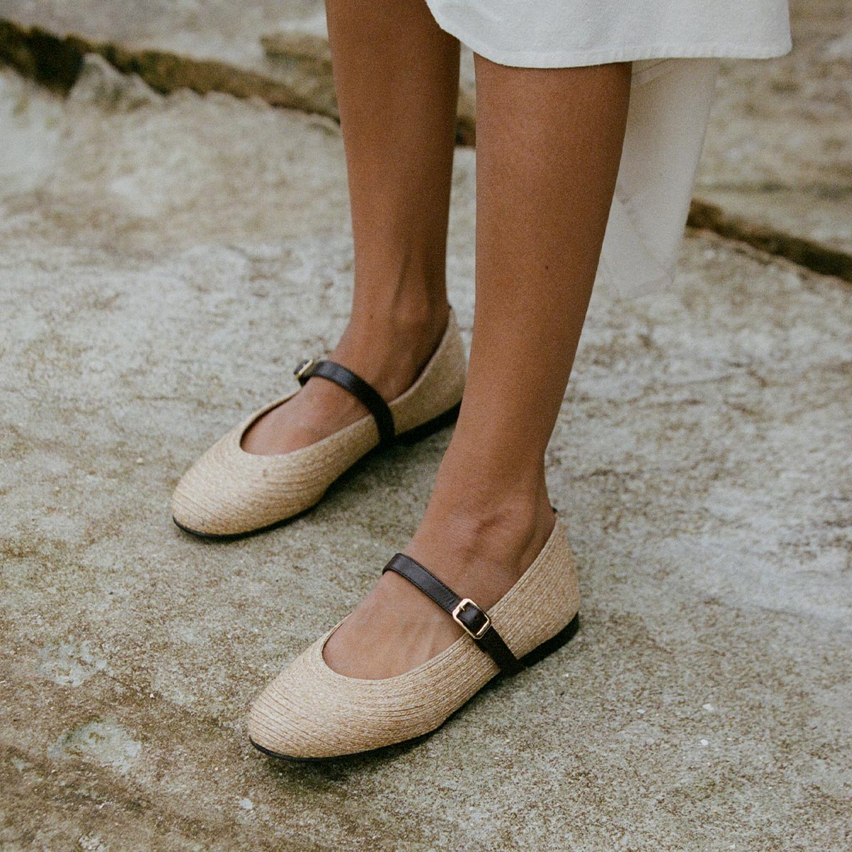 The Demi Jane in natural raffia, a ballet flat with a rounded toe and an adjustable strap for a secure fit.