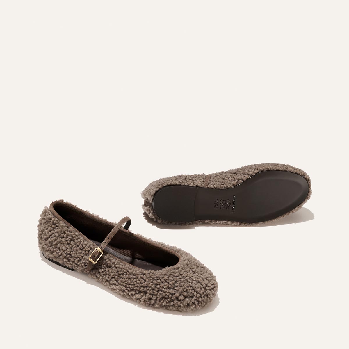 The Demi Jane in taupe shearling is a Mary Jane flat with a thin buckled strap, offering a touch of elegant femininity.