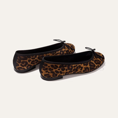 The Demi - Leopard Suede by margaux-development: handmade in Spain, these leopard-print ballet flats feature black trim and small front bows, shown on a light background.