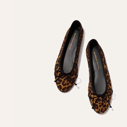 The Demi - Leopard Suede by margaux-development: handmade in Spain, these leopard print ballet flats feature black toe bows and offer stylish comfort—the perfect choice for chic footwear.