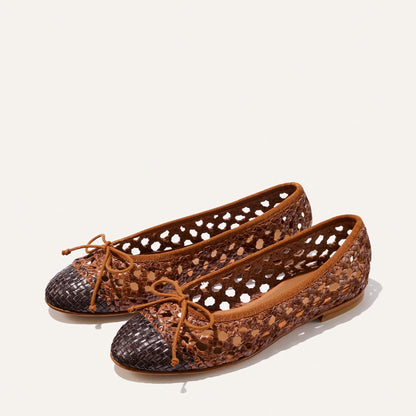 Brown and black perforated ballet flats on a white background
