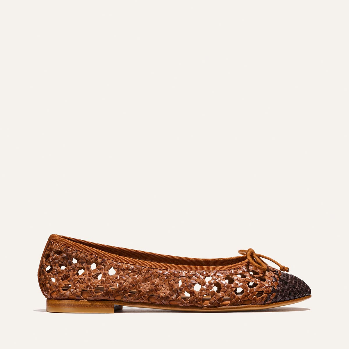 Brown flat shoe with cut-out design on a white background