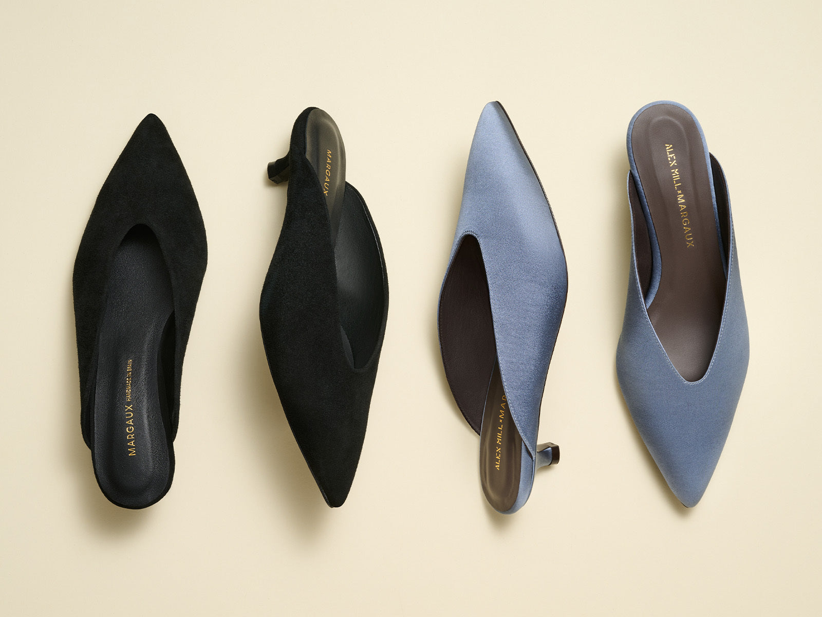 Two pairs of black and blue pointed-toe shoes on a beige background
