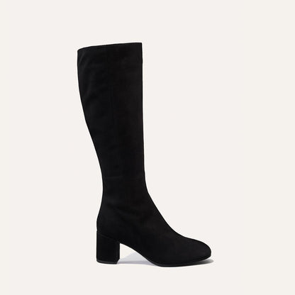 The Edie Boot in Black Suede, a sleek knee-high silhouette complemented by a comfortable 2.5-inch block heel and a hidden interior zipper for a fitted look.