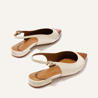 The Elise by margaux-development features stylish slingback shoes with cream cotton sides, tan saddle nappa pointed toes, and low block heels, beautifully displayed on a light background.